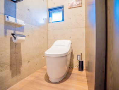 Modern washlet toilet room at Bayside Villa Miyako Island with concrete walls, electronic bidet features, and contemporary minimalist design.