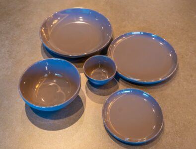 Premium ceramic dinnerware set at Bayside Villa Miyako Island featuring elegant blue-rimmed plates and bowls for fine dining experience.