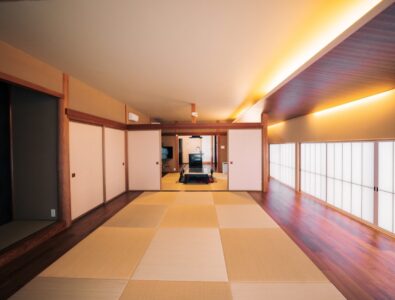 Spacious traditional Japanese living room at Enishiya Izumo Villa with tatami flooring, shoji screens, warm ambient lighting, and central hearth area.